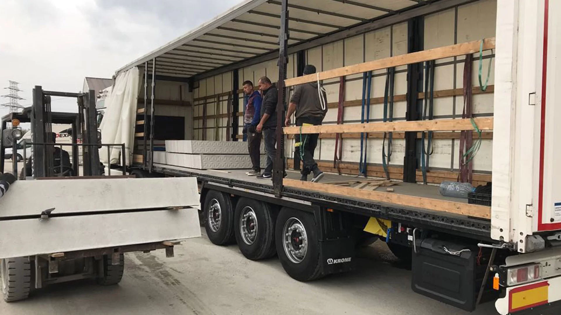 Transport gard - camion cu montatori incarcand panouri de gard prefabricat